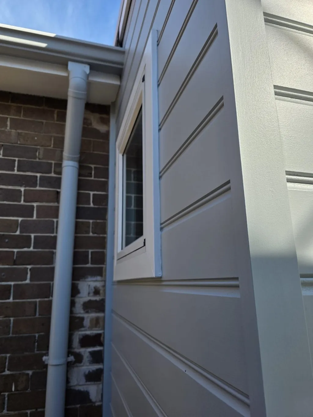 Close-up of repainted weatherboard cladding and window trim