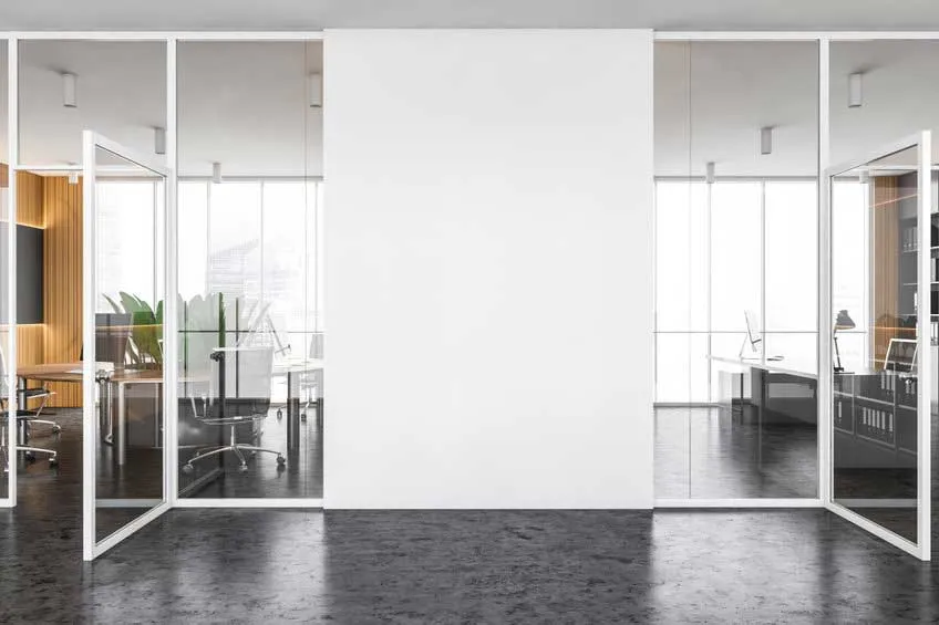 Office with glass partitions and plain white walls